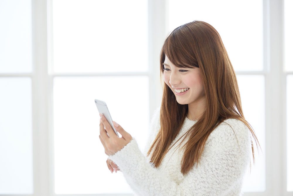 婚活でザオラルLINEをもらって笑う女性