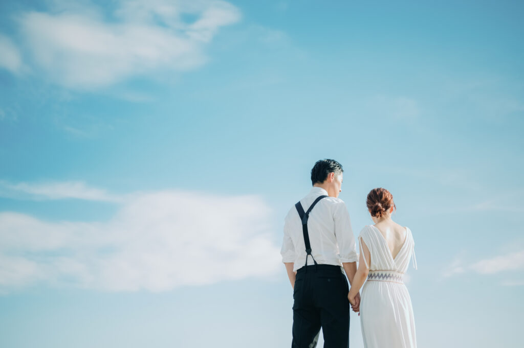 青空の下で結婚式を挙げる男女