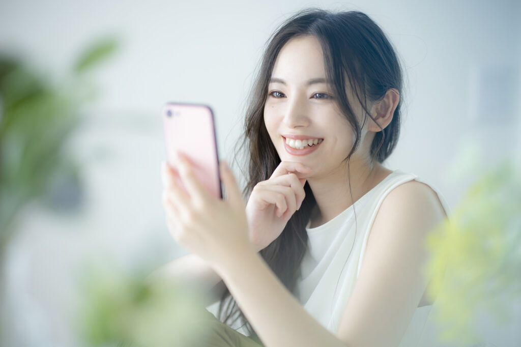 笑顔でスマホを眺める女性