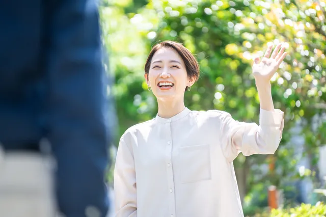 男性に笑顔で手を振る女性