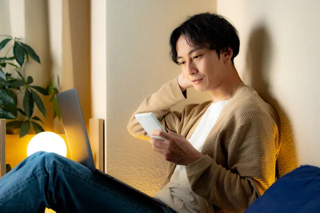 スマホを見て考える男性