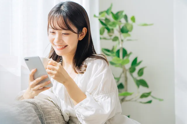 スマホを見て微笑む女性