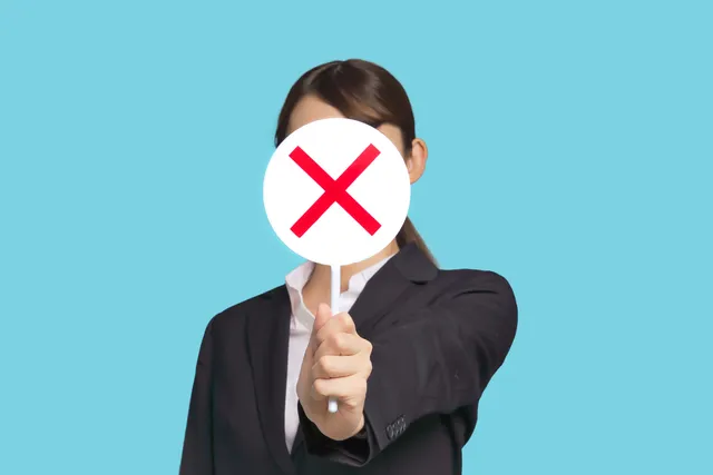 バツマークを示す女性