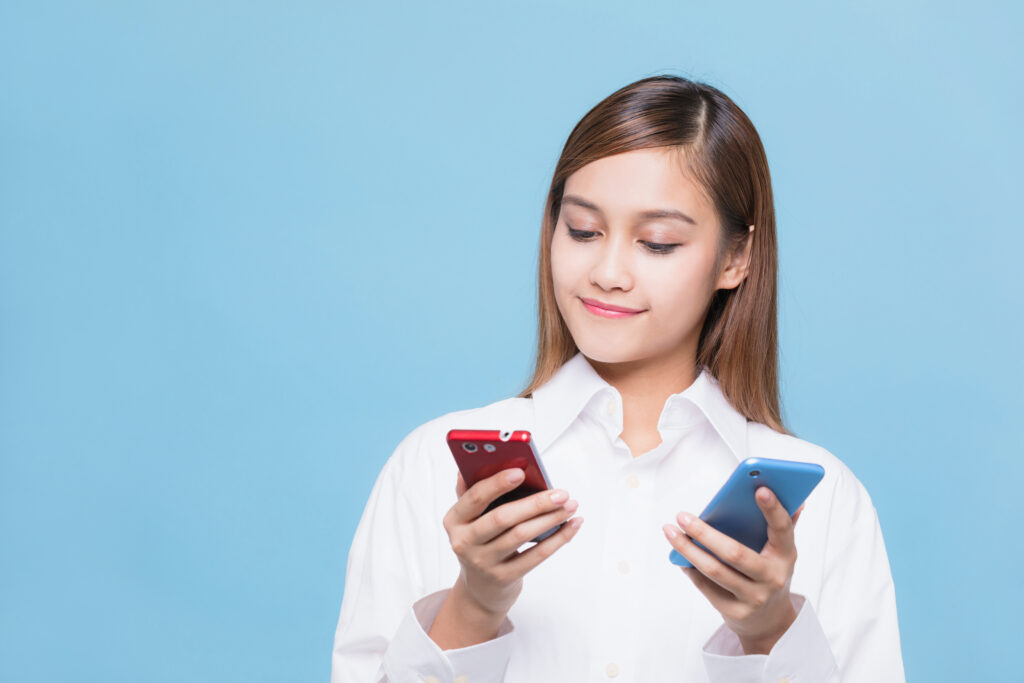 スマホを2つ持つ女性