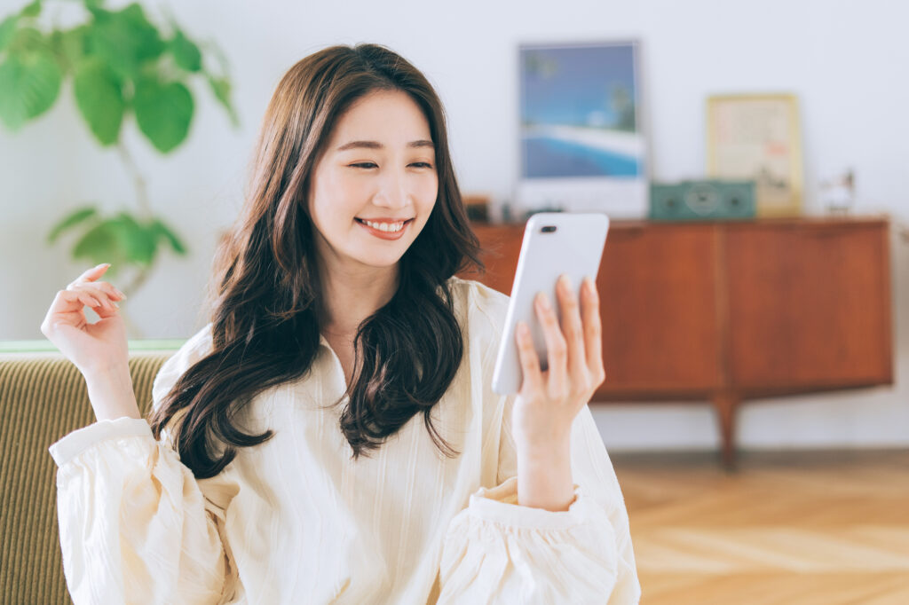 スマホを見て喜ぶ女性
