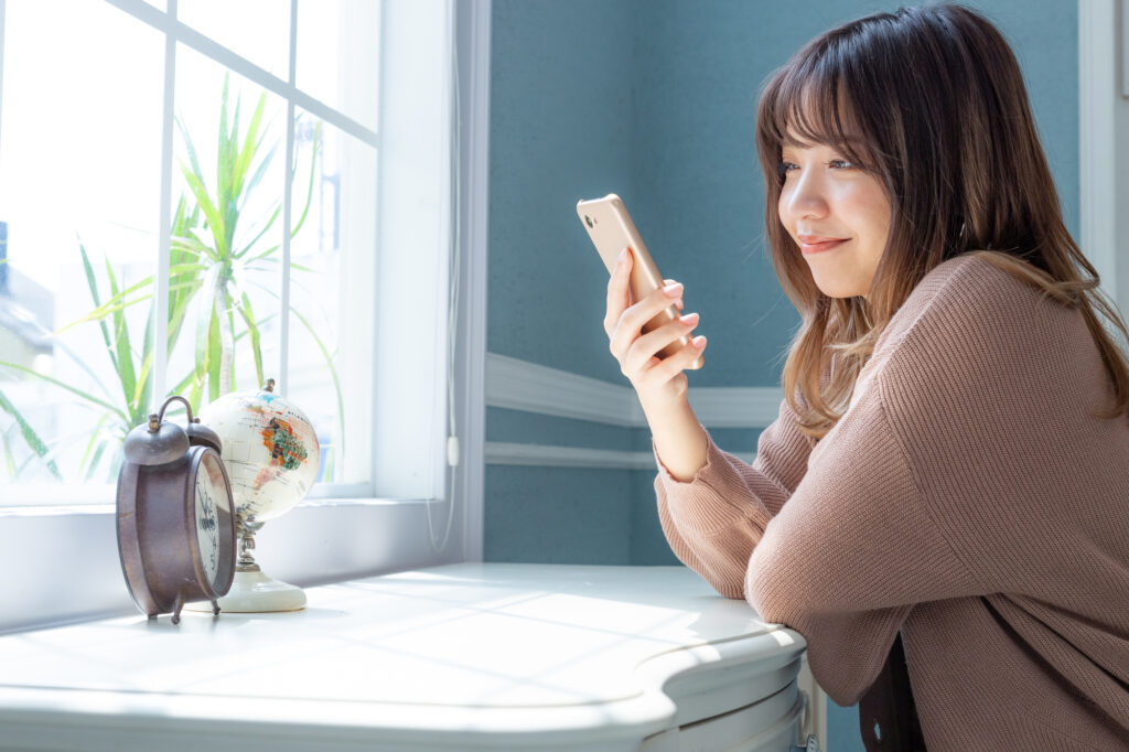 スマホを見て微笑む女性