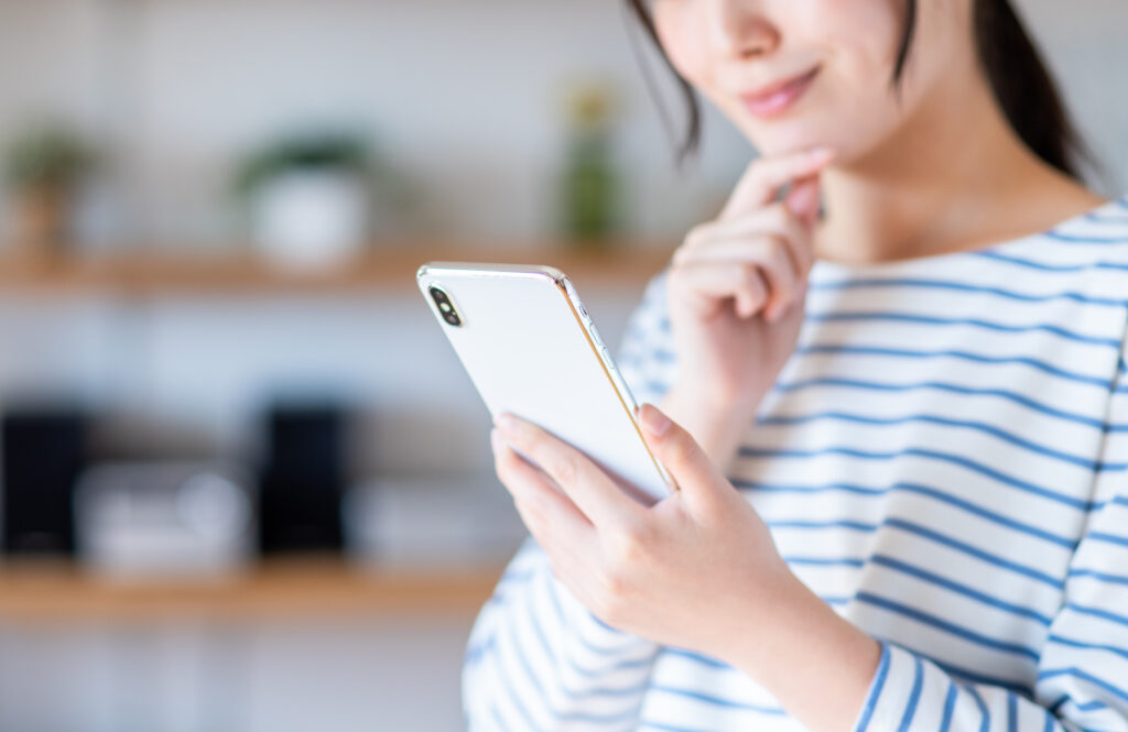 スマホを見て考える女性