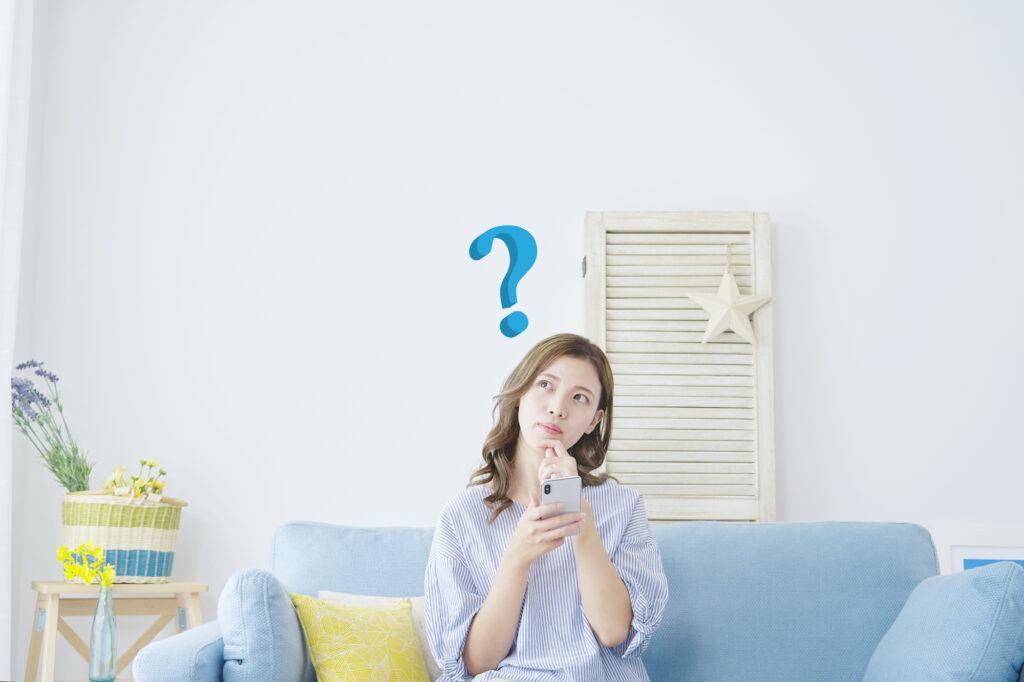 スマホを持って悩む女性