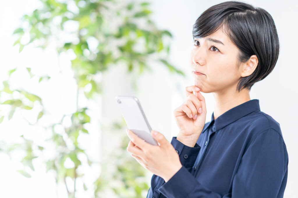 悩スマホを持ってむ女性