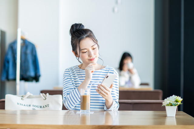 スマホを見て考える女性