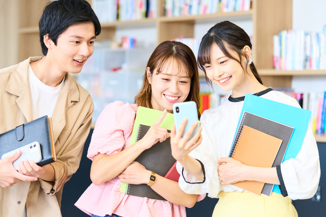 スマホを覗き込む大学生の男女