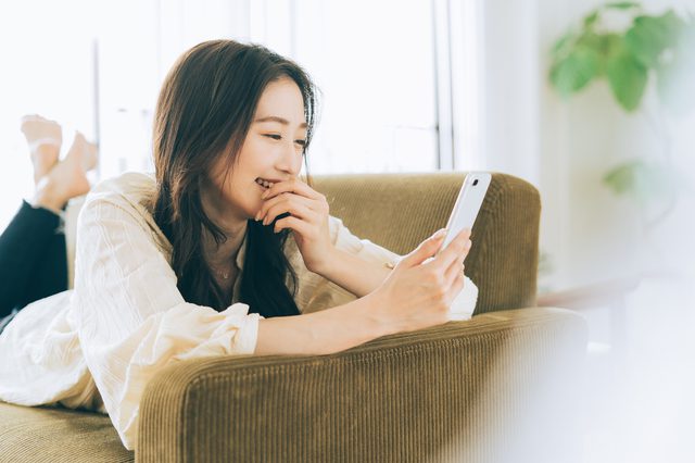 笑顔でスマホを操作する女性