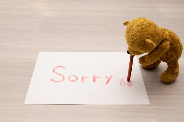 謝るクマのぬいぐるみ