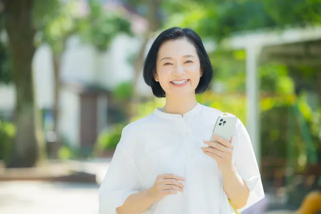 屋外で微笑むミドルシニア女性