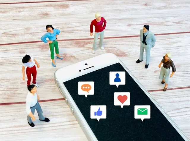 スマホを取り囲む男女の人形とアイコン