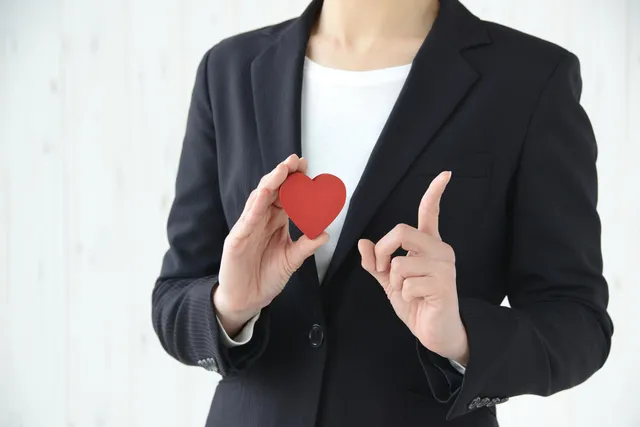 ハートを持ってポイントを示す女性