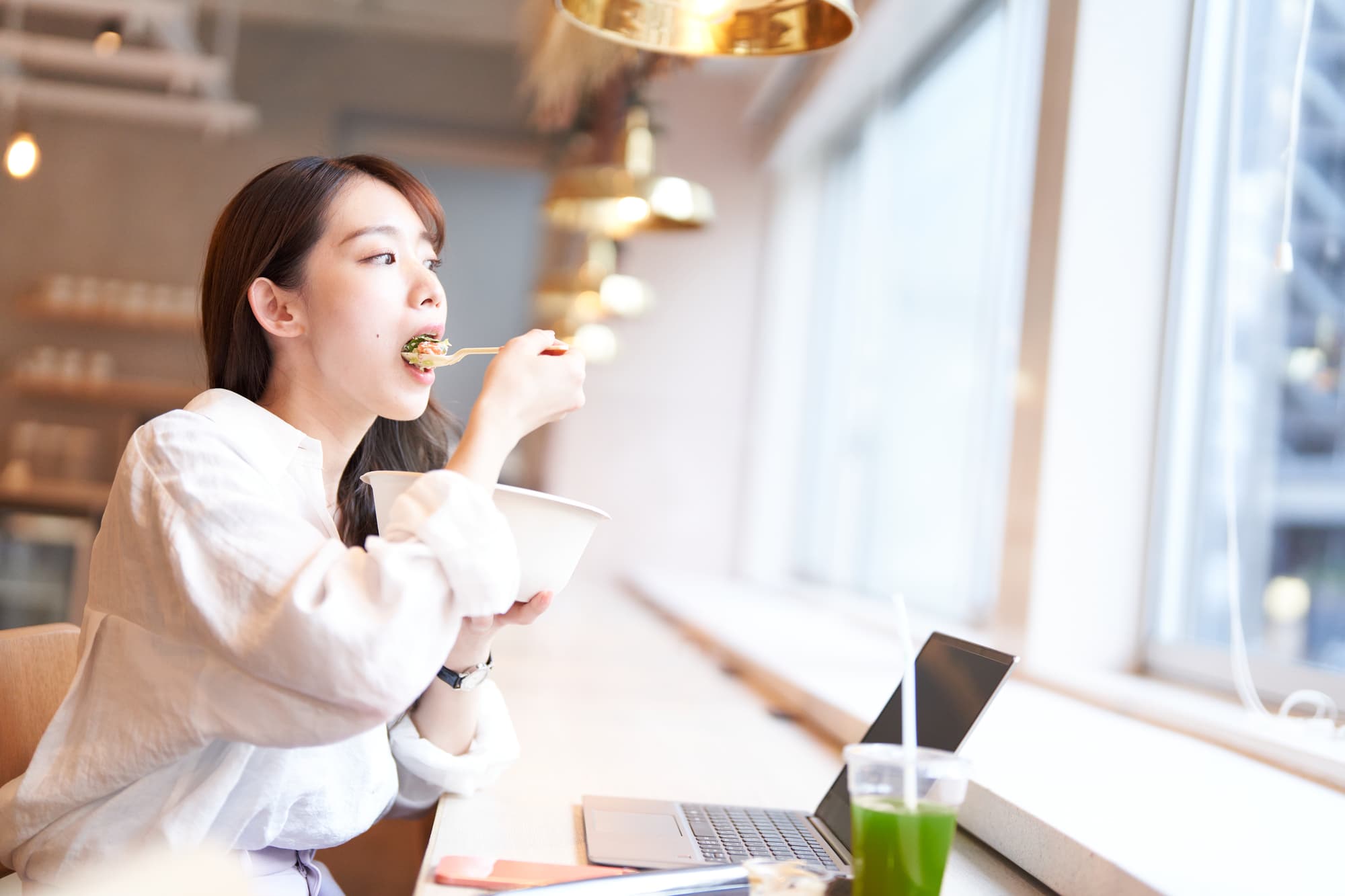 青汁と朝食を食べる女性